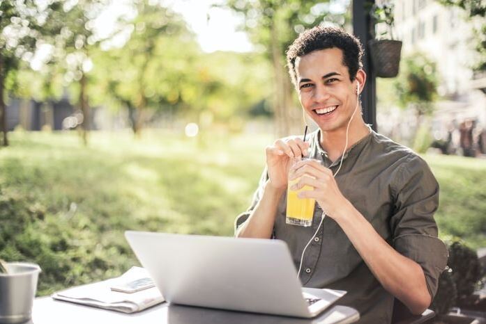 Young man drinking cooldrink while working on e-commerce business technology.