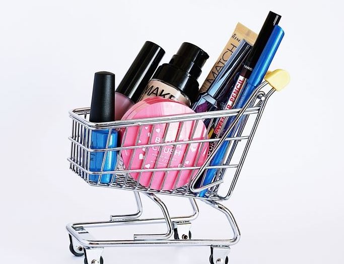 A small shopping trolley filled with makeup to represent customer service