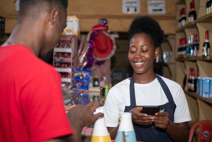 Black business women helping a customer during Black Friday sales.