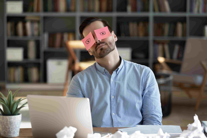 A man with sticky notes over his eyes
